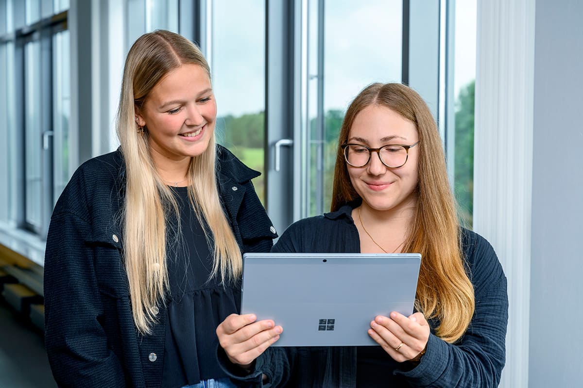 Zwei Mädchen schauen auf ein Tablet.