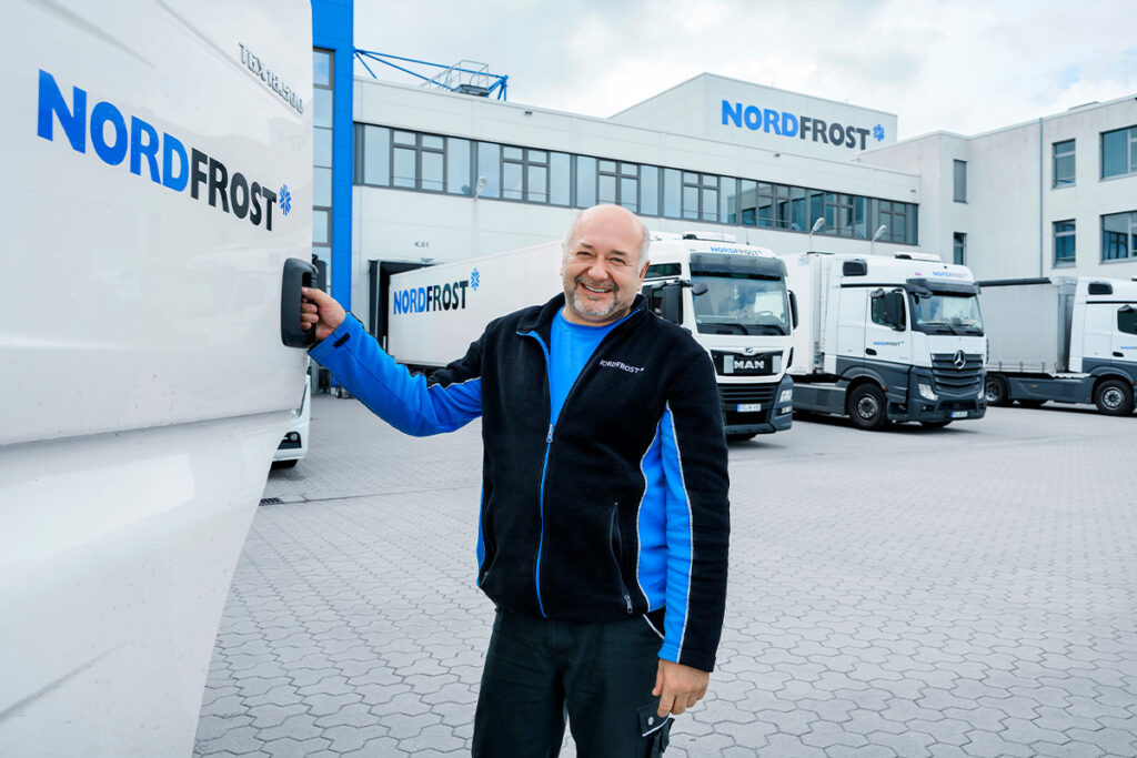 Der Mitarbeiter steht neben dem Nordfrost-Lkw.