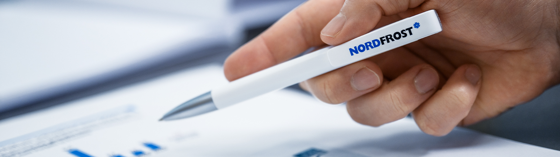 Man hält einen Nordfrost-Kugelschreiber in der Hand.