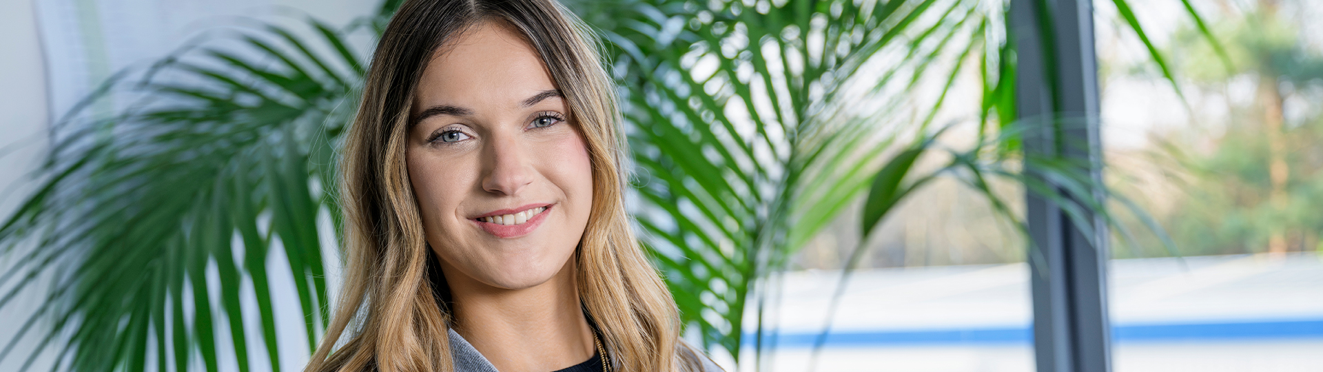 Praktikantin die am Arbeitsplatz lächelt