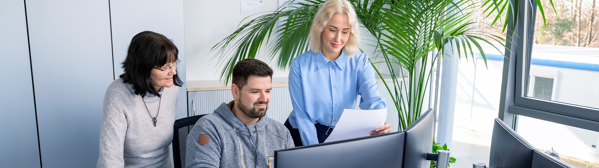 Verwaltungsmitarbeiter am Arbeitsplatz, die etwas besprechen